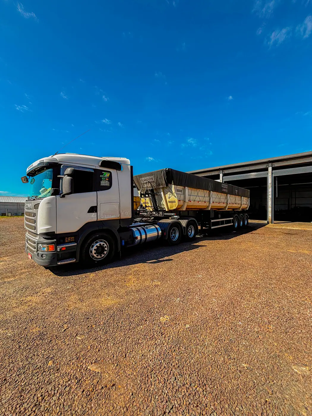 Caminhão da J3 Transportes acoplado a uma caçamba basculante, pronto para carregar